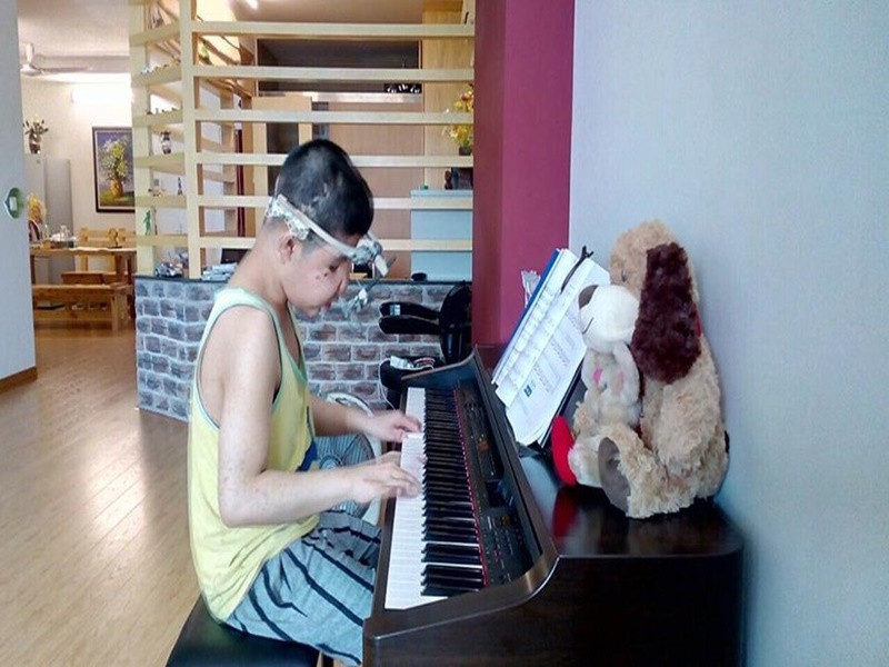 Từ lúc 1- 2 tuổi, Bôm đã tỏ ra thích thú với piano. Sau khi phẫu thuật bàn tay, con trai Quốc Tuấn rất chăm chỉ luyện đàn theo chương trình của nhạc viện. Âm nhạc không chỉ là niềm đam mê mà còn giúp Bôm quên đi những đau đớn vì bệnh tật. Ảnh: Vietnamnet.