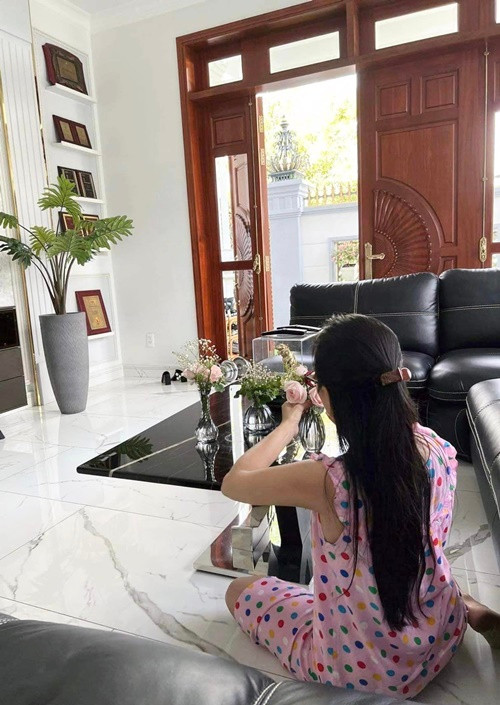 Nữ ca sĩ mặc đồ bộ ngồi bệt cắm hoa. Ảnh: FB Cẩm Ly.