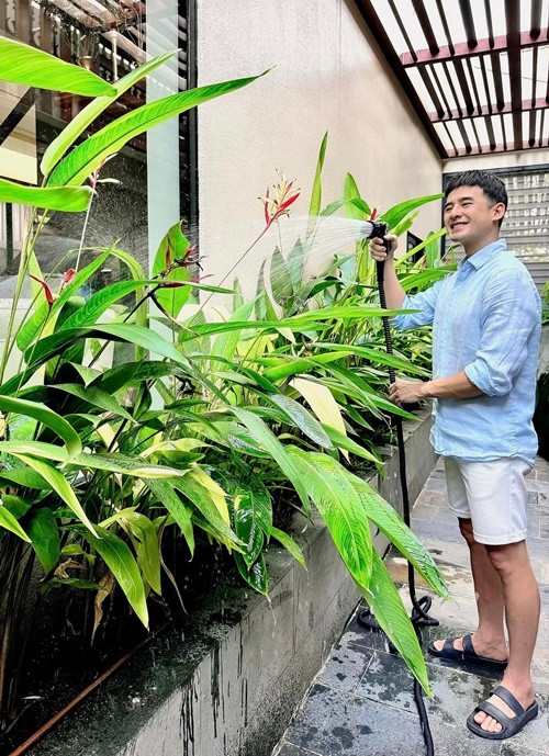 Nam diễn viên chăm chút cây trồng khu vực sân nhà.