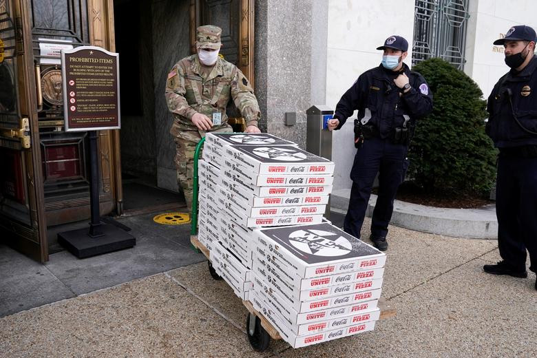 Một thành viên của Vệ binh Quốc gia mang những hộp bánh pizza tới tòa nhà Văn phòng Thượng viện Dirksen hôm 15/1.