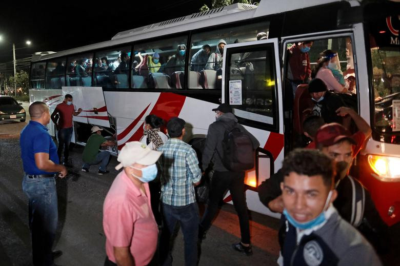 Các di dân có mặt tại một trạm xe buýt ở San Pedro Sula, Honduras, ngày 14/1.