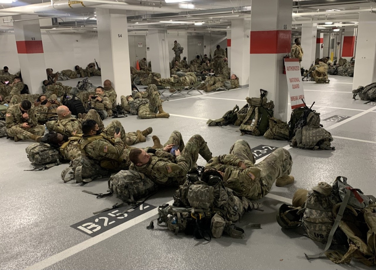 Hàng trăm binh sĩ Vệ binh Quốc gia bị dồn vào một bãi đỗ xe chật chội, dùng chung hai nhà vệ sinh. Phần lớn không thể ngủ được bởi ánh sáng chói của đèn huỳnh quang bên trong bãi để xe, hai binh sĩ tiết lộ. Một binh sĩ cho biết anh và các đồng đội phải ngủ trong khói thải từ những chiếc ôtô liên tục ra vào bãi gửi xe. Một binh sĩ thậm chí suýt bị ôtô cán qua. Tổng cộng 5.000 binh sĩ đang làm nhiệm vụ bảo vệ Điện Capitol, Politico cho biết. Ảnh: Washington Post.