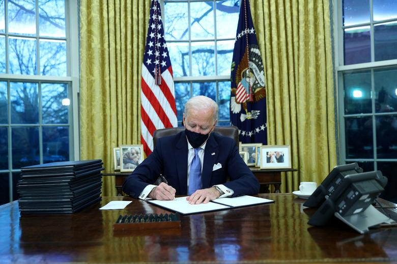 Tổng thống Joe Biden ký các sắc lệnh Hành pháp tại Phòng Bầu dục của Nhà Trắng ngày 20/1/2021.