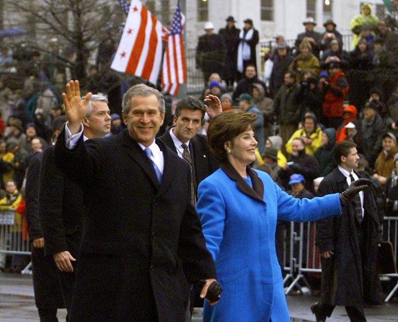 Tổng thống George W. Bush và phu nhân Laura Bush vẫy chào đám đông khi đi bộ trong lễ diễu hành ngày 20/1/2001.