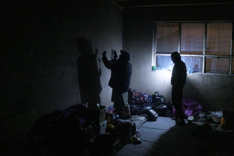 Các di dân sắp xếp đồ đạc bên trong một nhà máy bỏ hoang.