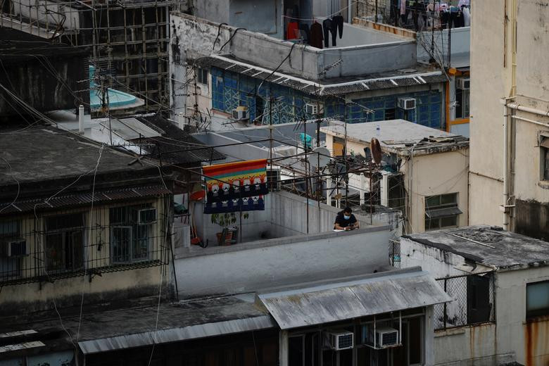 Một người dân đeo khẩu trang đứng trên tầng thượng của một ngôi nhà ở Hong Kong hôm 23/1.