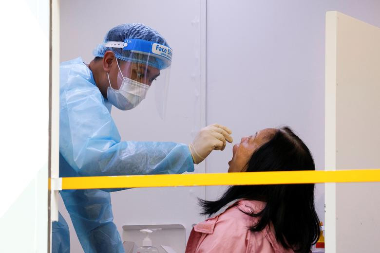 Người phụ nữ được lấy mẫu xét nghiệm COVID-19 tại một trung tâm xét nghiệm tạm thời hôm 22/1.