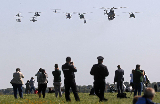 Những chiếc trực thăng bay biểu diễn, trong khi du khách tranh thủ ghi hình. Tiếng động cơ máy bay gầm rú là một trải nghiệm thú vị đối với du khách tại các triển lãm hàng không. Ảnh: EFE.