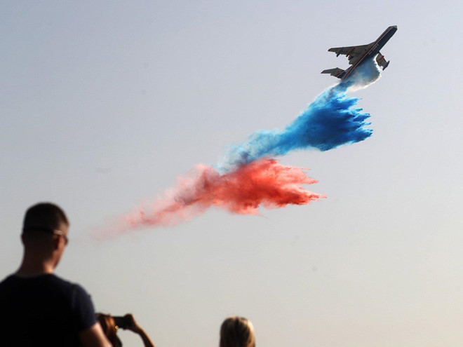 Thủy phi cơ Beriev Be-200 trình diễn khả năng thả nước với nhiều màu sắc. Đây là một phần trong các hoạt động giới thiệu tính năng của máy bay có thể sử dụng cho nhiệm vụ cứu hỏa. Ảnh: EFE.