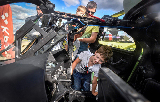 Những đứa trẻ tỏ ra thích thú khi được tham quan buồng lái trực thăng chiến đấu Mi-24. Ảnh: AFP.