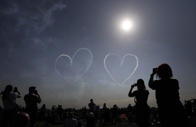 Hàng nghìn du khách tranh thủ lưu lại khoảnh khắc đẹp khi các máy bay chiến đấu vẽ hình trái tim trên bầu trời. Ảnh: EFE.