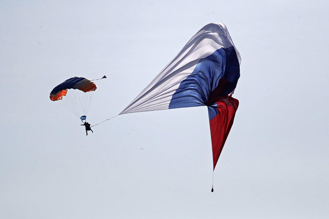 Một binh sĩ nhảy dù mang theo quốc kỳ Nga. Triển lãm MAKS được tổ chức lần đầu vào năm 1992 và nhanh chóng trở thành một trong những sự kiện hàng không được mong đợi nhất ở Nga. Ảnh: EFE.