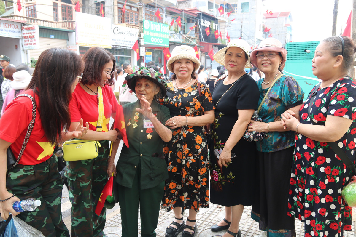 Người dân chụp ảnh cùng bà Trần Thị Nhĩ (SN 1936, quê Thanh Hóa, hiện trú tại Tổ 10, phường Tân Thanh, thành phố Điện Biên Phủ, Điện Biên) là một cựu thanh niên xung phong tham gia phục vụ Chiến dịch Điện Biên Phủ.