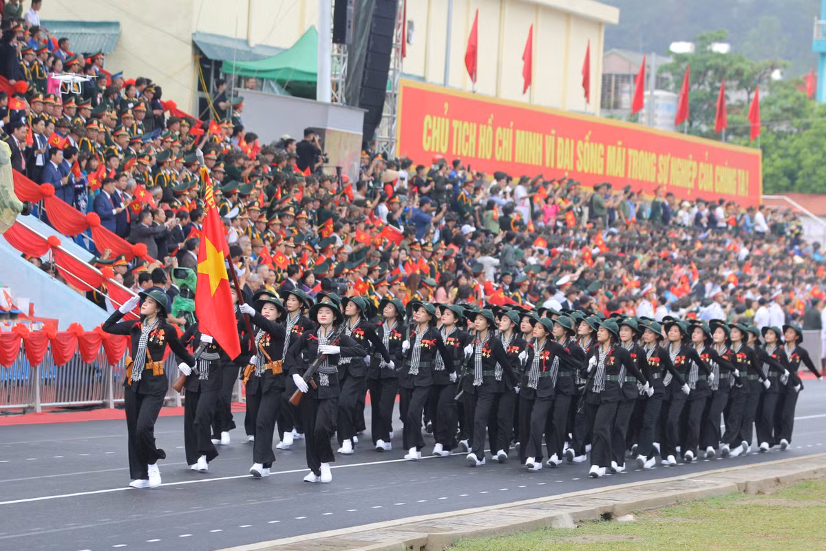 Trên khán đài, mọi người vẫy cờ hoa cổ vũ cho các khối diễu hành.