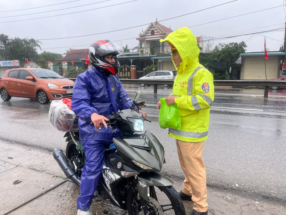 CSGT vừa trao đồ ăn, nước uống vừa tuyên truyền người dân chấp hành luật giao thông đường bộ.