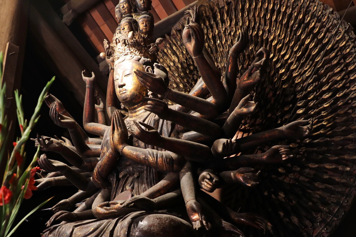 Tượng ngồi trong tư thế thiền định, có 11 mặt chính nhìn ra phía trước, và 2 mặt phụ ở 2 bên, đầu đội mũ “ thiên quan”. Đầu tượng tạo thành nhiều lớp, trên cùng là tượng A Di Đà ngồi trên tòa sen trong tư thế thiền định.