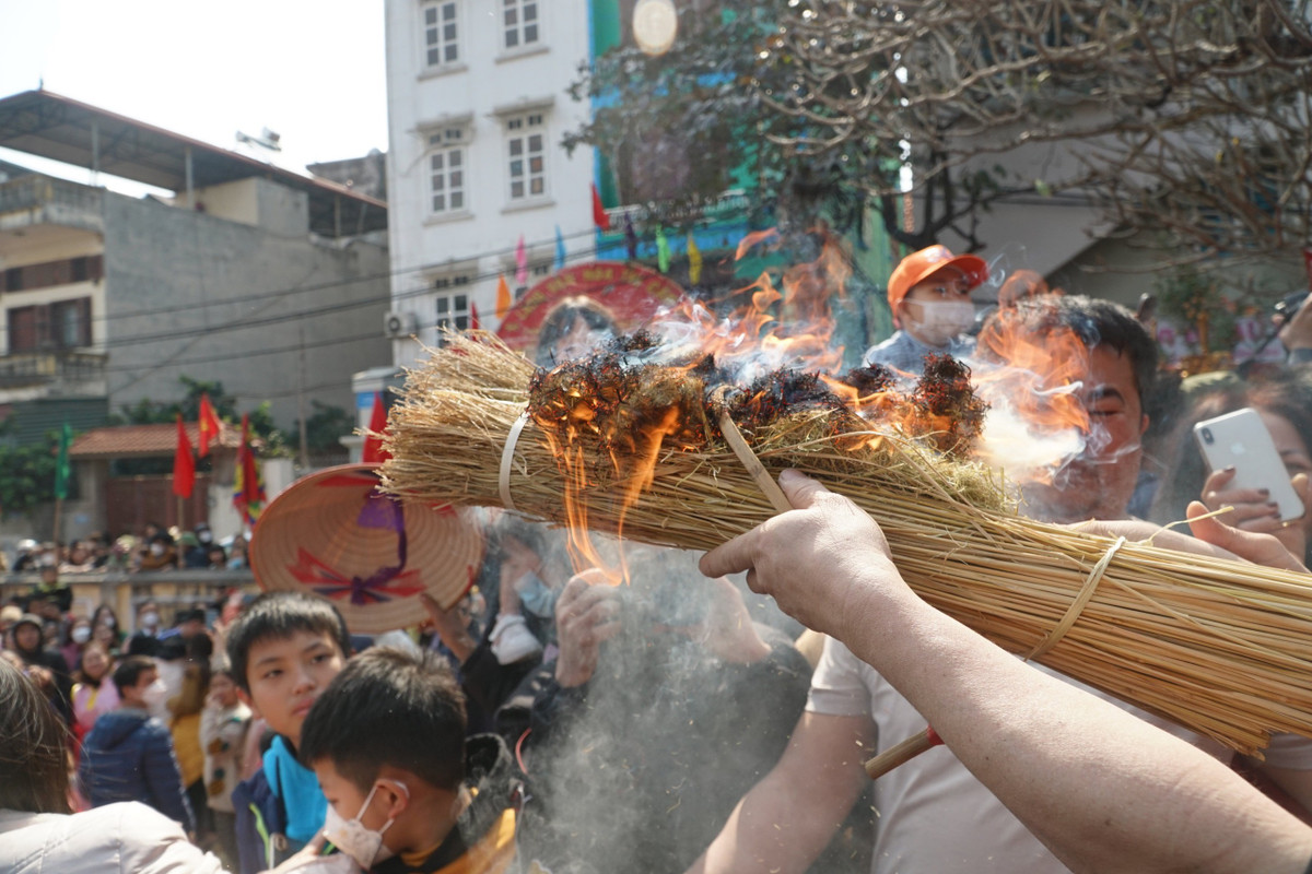 Các thành viên ra sức thổi vào bó rơm để lửa bén to, dùng mồi lửa này để thổi cơm. Mồi lửa đầu tiên bén rơm cũng là lúc không khí trong sân đình trở nên náo nhiệt.