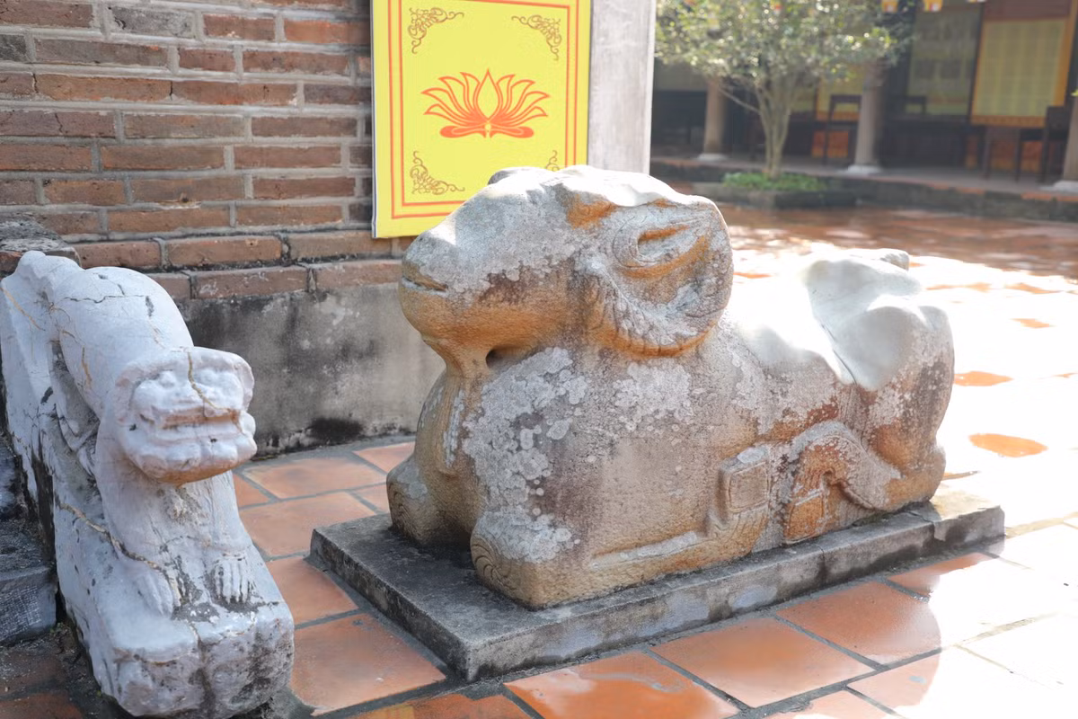 Phía trước tam cấp cửa phía Tây có 2 tượng sóc đá mang phong cách nghệ thuật thời Lê Trung Hưng. Bên trái có một tượng cừu đá dài 1,33 m, cao 0,8 m (dấu ấn của văn hoá phương Bắc, phản ánh sự hiện diện của Thái thú Sĩ Nhiếp khi đóng trị sở ở thành Luy Lâu).