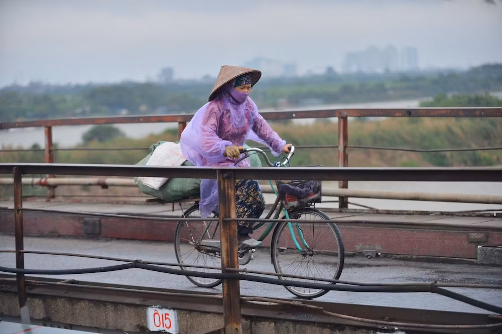 Hình ảnh người dân thấm sâu cái lạnh khi đi qua cầu Long Biên. (Ảnh: Saostar)