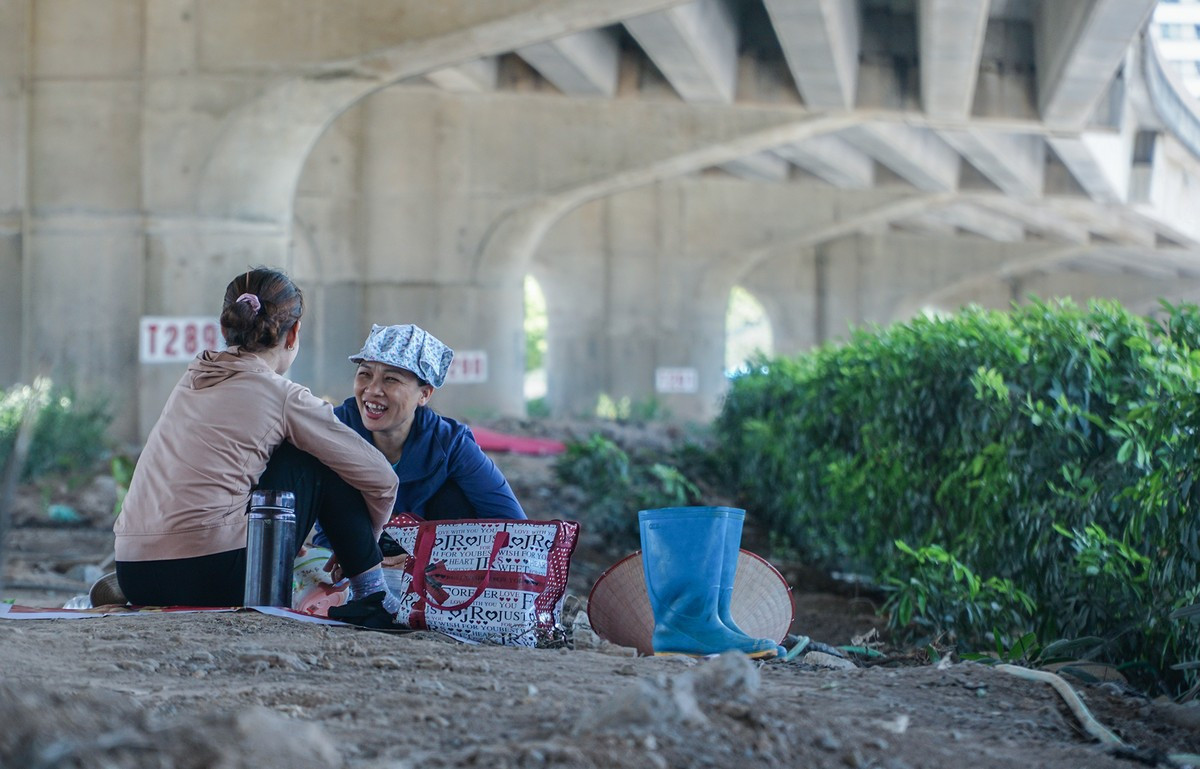 Dưới gầm cầu đường Vành đai 3 trên cao, nhiệt độ chênh lệch so với ngoài trời gần 10 độ C, buổi trưa hai lao động nữ đã vào đây nghỉ ngơi, ăn cơm.