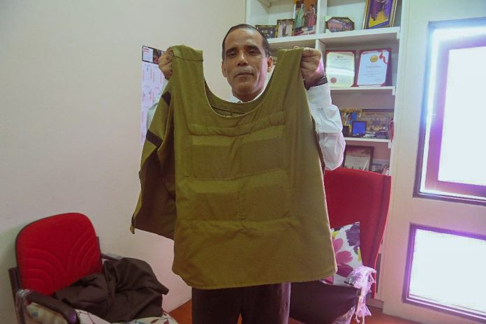 Loại áo giáp mới này được đặt tên là Techno - Economic Hard Body Armour, các tấm cứng được đặt trong các túi phía trước và sau như một chiếc áo giáp chống đạn thông thường.Tấm cứng của áo đáp ứng tốt yêu cầu và đạt chuẩn chống đạn cấp III (chặn được đạn súng trường 7.62mm) của Cơ quan Tư pháp Quốc gia Malaysia (NIJ). Ảnh: Tiến sĩ Mohammad Jawaid - Trưởng nhóm nghiên cứu với chiếc áo chống đạn được làm bằng dừa của mình.