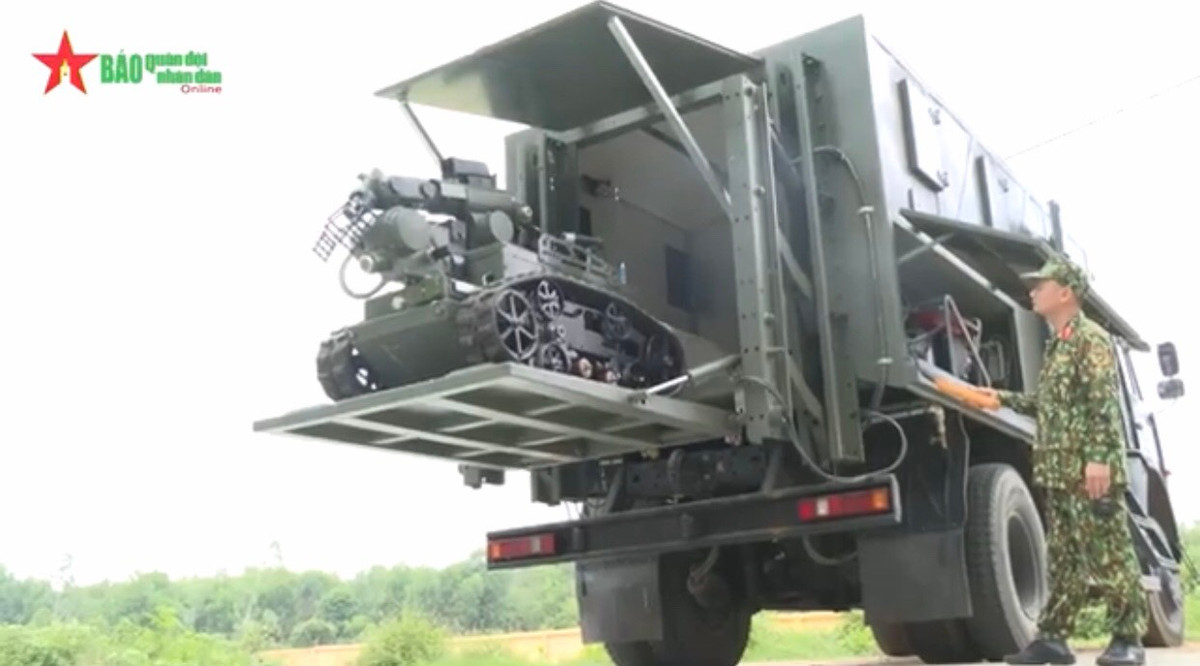 Robot được tích hợp lên xe Kamaz 43253 trinh sát chuyên dụng, cho phép triển khai đến những khu vực khác nhau nhanh chóng và thuận tiện, đồng thời có carbin bảo quản Robot để tránh phải ảnh hưởng bởi những tác nhân từ thời tiết. Ảnh: Sĩ quan Hóa học triển khai hạ Robot từ trong carbin xe trinh sát.