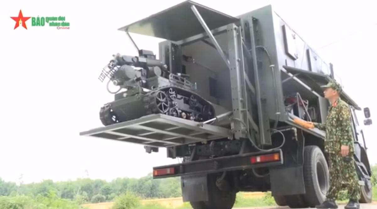 Robot được tích hợp lên xe Kamaz 43253 trinh sát chuyên dụng, cho phép triển khai đến những khu vực khác nhau nhanh chóng và thuận tiện, đồng thời có carbin bảo quản Robot để tránh phải ảnh hưởng bởi những tác nhân từ thời tiết. Ảnh: Sĩ quan Hóa học triển khai hạ Robot từ trong carbin xe trinh sát.
