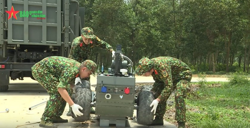 Nó có 2 hệ thống truyền động có thể chọn là bánh xích hoặc bánh lốp tuỳ vào nhiệm vụ. Việc chuyển đổi từ bánh xích sang bánh lốp của Robot sẽ mất thời gian 10 phút. Đồng thời có khả năng leo dốc từ 30 độ - 48 độ. Ảnh: Chiến sĩ thay hệ thống bánh xích sang bánh lốp cho Robot RBH-18.
