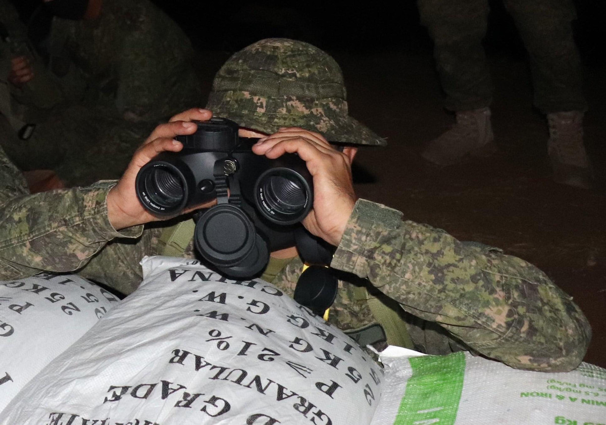 Ảnh: Binh sĩ thực hành quan sát mục tiêu giả định của cuộc diễn tập bằng ống nhòm.