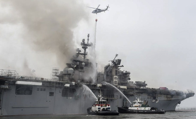 Tàu USS Bonhomme Richard (LHD-6) là một tàu đổ bộ tấn công thuộc lớp Wasp của Hải quân Hoa Kỳ, chính thức biên chế từ năm 1998 và có lượng giãn nước đầy tải hơn 41.000 tấn. Con tàu đã bất ngờ bốc cháy khi đang sửa chữa tại cảng nhà ở vịnh San Diego, rất may lúc đó có rất ít thủy thủ trên con tàu và đã không có thiệt hại về người nào xảy ra. Ảnh: Tàu cứu hộ và trực thăng tưới nước lên tàu LHD-6 nhằm khống chế ngọn lửa âm ỉ.