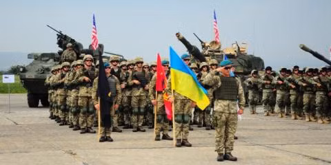 Nhằm đáp trả lại cuộc tập trận trên do Nga khởi xướng, Mỹ đã phối hợp cùng Ukraine tổ chức cuộc diễn tập “Đinh ba chớp nhoáng 2020” được tổ chức tại khu vực Yavoriv, miền Tây Ukraine. Sự kiện cũng thu hút sự góp mặt của 4.000 binh sĩ đến từ 10 quốc gia nhằm gây thanh thế và phô trương sức mạnh cơ bắp để dằn mặt đối thủ lớn trong khu vực, cùng với đó là củng cố tinh thần đoàn kết giữa Mỹ và các đồng minh trong khu vực, đặc biệt là Ukraine - đất nước tuyến đầu trong công cuộc chống Nga. Ảnh: Lính Mỹ và Ukraine trong khuôn khổ một cuộc diễn tập đa phương.