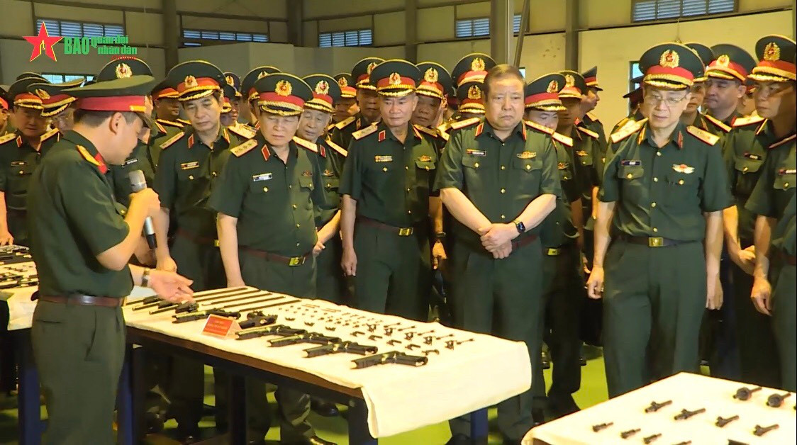 Qua Hội nghị, Tổng cục Công nghiệp Quốc phòng đã giới thiệu cho các cán bộ của Bộ Quốc phòng về rất nhiều loại trang thiết bị, khí tài, vũ khí Việt Nam tự chế tạo. Trong đó, đặc biệt nổi bật và thu hút sự chú ý đó là các mẫu súng mới cực kỳ hiện đại, mẫu mã bắt mắt, tính tùy biến cao và thông số kỹ thuật vượt trội. Ảnh: Cán bộ Tổng cục giới thiệu chi tiết về loại súng ngắn Jericho 941 mới cho đoàn đại biểu.