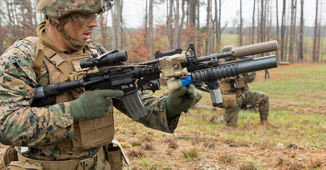 Tuy nhiên, rất nhiều nước đã loại bỏ vị trí xạ thủ bắn súng phóng lựu trong biên chế tiểu đội bộ binh cũng như súng phóng lựu cầm tay. Mà thay vào đó là trang bị các loại súng phóng lựu kẹp nòng cho súng trường như M203/M320 của Mỹ hay GP-25/30 của Nga. Ảnh: Binh sĩ Mỹ thao tác nạp đạn cho súng phóng lựu kẹp nòng M203 của gắn dưới khẩu M4 Carbin.