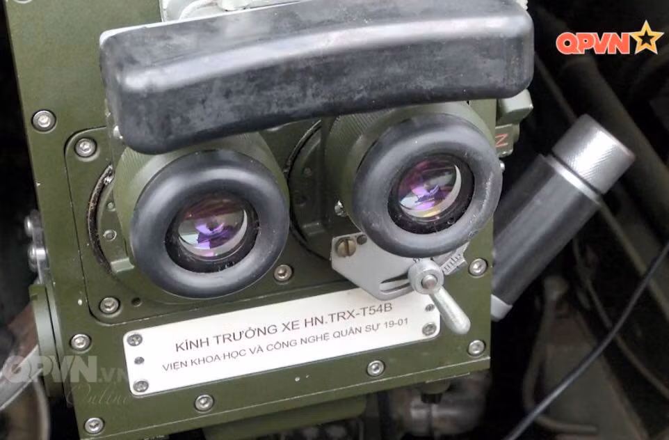 Đặc biệt, hệ thống điện tử của xe được hiện đại hóa mạnh mẽ, có thể sánh ngang với các xe tăng hiện đại như tăng cường hệ thống đo xa Laser, hệ thống cảm biến thời tiết, kính ngắm ảnh nhiệt, hệ thống kiểm soát hỏa lực vượt trội tính toán cho phép xe có thể vừa hành tiến vừa khai hỏa với độ chính xác cao. Ảnh: Kính ngắm trưởng xe trên xe tăng T-54M của Việt Nam. Nguồn: QPVN.