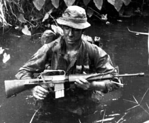 Súng tiểu liên M16 đã được Quân đội Mỹ sử dụng liên tục trong hơn 50 năm qua; đây là một vũ khí bộ binh đã được thử thách qua thời gian, tin cậy và vẫn còn khả năng cải tiến dưới dạng thay đổi về cỡ nòng hoặc hệ thống trích khí. Ảnh: Lính Mỹ tham chiến ở chiến trường Việt Nam với súng tiểu liên M16 - Nguồn: Wikipedia.