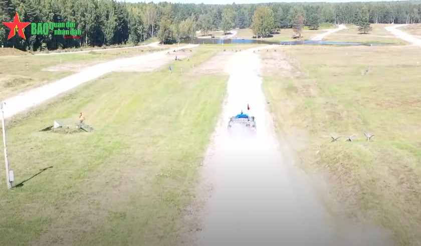 Sau khi các thành viên của kíp xe thứ nhất vượt qua bãi vật cản thể lực, các thành viên thực hiện động tác trao “gậy tiếp sức” là các hộp tiếp đạn cho kíp xe thứ hai ở vị trí sẵn sàng để tiến hành chặng đua thứ 2. Ảnh: QĐND.