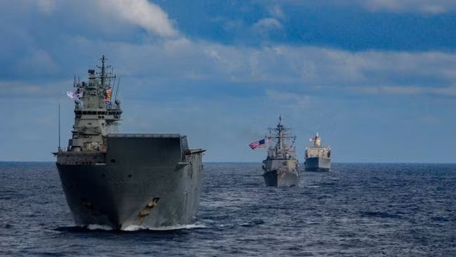 Cuộc diễn tập được Mỹ tổ chức dự kiến diễn ra từ ngày 19/7 cho đến ngày 23/7 với sự tham gia của nhóm tác chiến tàu sân bay USS Ronald Regean (CVN-76) của Hạm đội 7 Hoa Kỳ, tàu chiến của lực lượng phòng vệ biển Nhật Bản và nhóm tác chiến tàu sân bay trực thăng HMAS Canberra của Hải quân Hoàng gia Australia. Hoạt động diễn ra trong bối cảnh cả 3 nước trên đều chỉ trích các động thái gây hấn của Trung Quốc tại khu vực tây Thái Bình Dương trong đó có biển Đông và biển Hoa Đông. Ảnh: Tàu sân bay trực thăng HMAS Canberra của Australia tại cuộc diễn tập, phía sau là một khu trục hạm mang tên lửa dẫn đường Arleigh Burke của Hải quân Mỹ trong cuộc diễn tập.