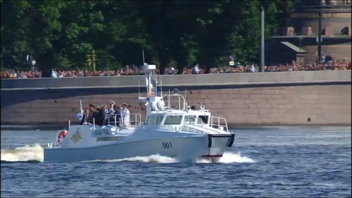 Tàu tuần tra cao tốc Raptor sơn màu trắng được vinh dự thực hiện nhiệm vụ chở Tổng thống Putin duyệt đội hình duyệt binh. Đây là loại tàu chính thức đi vào biên chế Hải quân Nga từ năm 2014, chuyên dùng để chở lính đổ bộ đánh chiếm mục tiêu cũng như cứu hộ cứu nạn, tuần tra ven bờ. Ảnh: Tổng thống Putin và các nhân vật cấp cao của quân đội và Chính phủ Nga trên chiếc Raptor mang số hiệu 001.