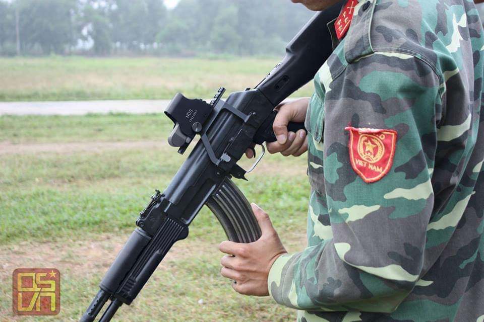 Bộ gá này giúp súng mở rộng thêm các loại phụ kiện như kính nhìn đêm, kính ngắm quang học, kính ngắm điểm đỏ để có thể nâng cao khả năng ngắm bắn của binh sĩ trên chiến trường, cũng như khả năng tác chiến trong điều kiện đêm tối. Đây có thể coi là một cải tiến khá quan trọng và đắt giá trên những khẩu AKn so với các loại AK-47 đời cũ. Ảnh: Chiến đấu viên thử nghiệm một khẩu súng trường AKn với kính ngắm kiểu Holo Sight được gắn lên súng nhờ bộ gá. Ảnh: Quân sự Việt Nam.