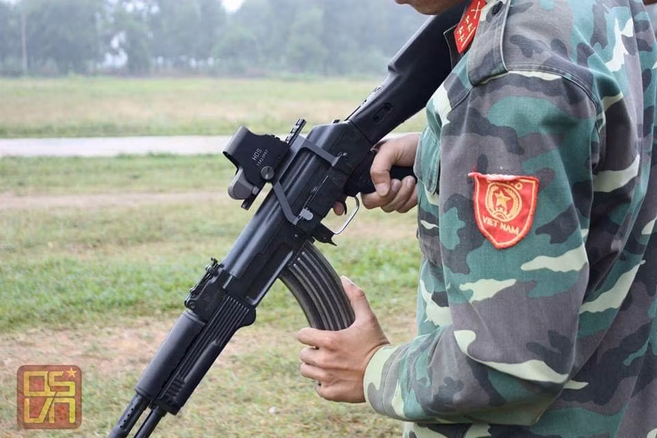 Bộ gá này giúp súng mở rộng thêm các loại phụ kiện như kính nhìn đêm, kính ngắm quang học, kính ngắm điểm đỏ để có thể nâng cao khả năng ngắm bắn của binh sĩ trên chiến trường, cũng như khả năng tác chiến trong điều kiện đêm tối. Đây có thể coi là một cải tiến khá quan trọng và đắt giá trên những khẩu AKn so với các loại AK-47 đời cũ. Ảnh: Chiến đấu viên thử nghiệm một khẩu súng trường AKn với kính ngắm kiểu Holo Sight được gắn lên súng nhờ bộ gá. Ảnh: Quân sự Việt Nam.