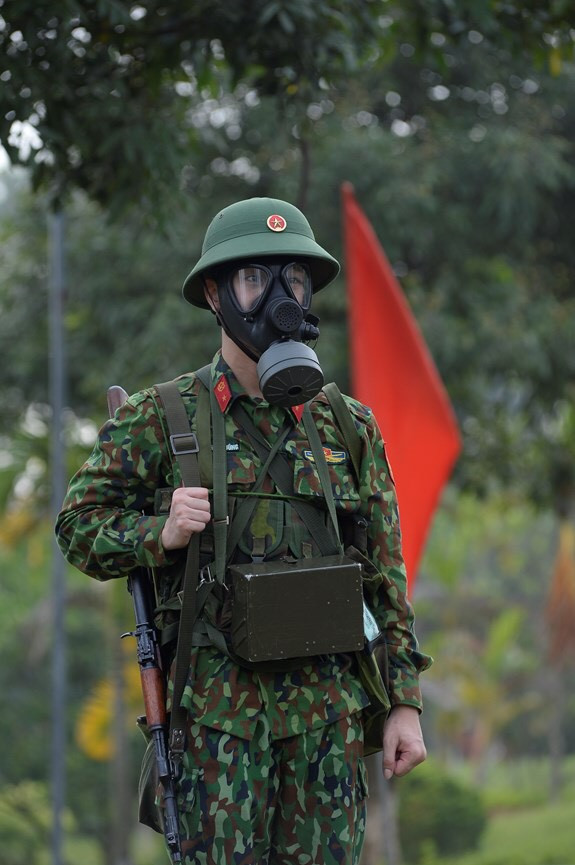 Trang bị không thể thiếu đối với chiến sĩ trong việc chống lại địch sử dụng vũ khí hoá học - sinh học đó chính là mặt nạ phòng hoá. Hiện nay, Quân đội ta đang đại trà loại mặt nạ MV-5 do Việt Nam tự chế tạo cho chiến sĩ bộ binh. Đây là khí tài có tính thuận tiện cao, kính rộng cho phép người lính có tầm quan sát tốt, cộng với việc cục lọc không khí có thể nhanh chóng thay thế dễ dàng, có tính năng vượt trội các loại cũ. Ảnh: Chiến sĩ với mặt nạ phòng hoá MV-5.