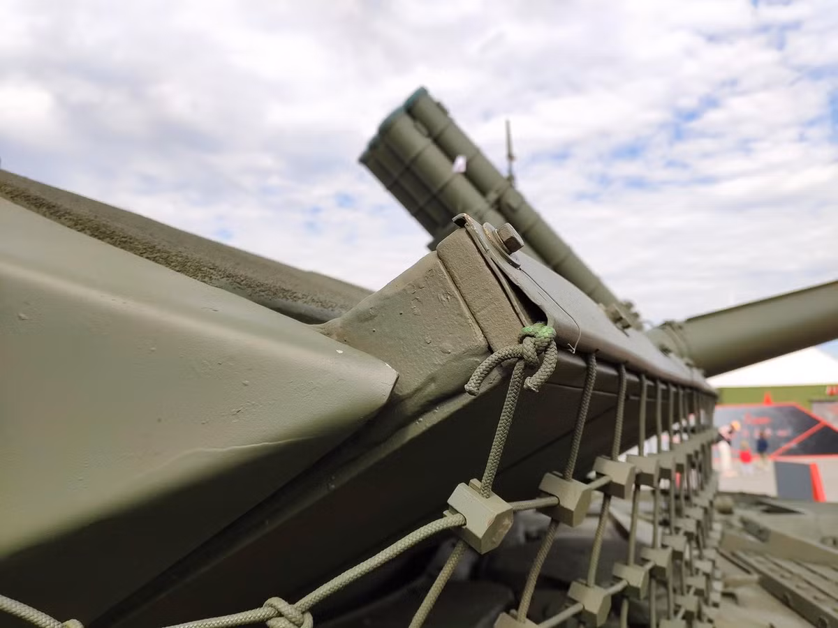 Về vị trí bố trí của kíp lái, T-90M vẫn giữ nguyên giống như trên dòng T-90 với thành phần 3 người, lái xe ngồi ở giữa, phía dưới pháo chính, trưởng xe sẽ ngồi ở bên phải tháp pháo có nhiệm vụ chỉ huy và quan sát toàn cảnh, đồng thời điều khiển Moldun súng máy 12.7mm, pháo thủ ngồi ở bên trái tháp pháo có nhiệm vụ ngắm bắn và tác xạ pháo chính 125mm cùng súng máy đồng trục 7.2mm. Ảnh: Giáp lưới trên xe tăng T-90M.