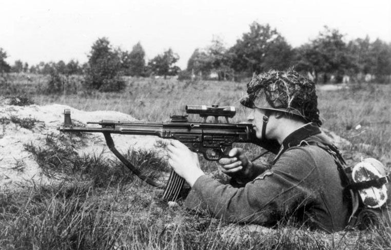 StG 44 sử dụng đạn cỡ 7,92x33 với hộp tiếp đạn 30 viên; MP44 có thể bắn phát một, sức mạnh, tầm bắn xa và hình dáng như súng trường; bên cạnh đó súng có tốc độ bắn nhanh như tiểu liên MP-40 (tốc độ bắn lên tới 600 viên/phút), băng đạn cong và tay cầm giống súng tiểu liên. Ảnh: Lính Đức với khẩu StG 44 trong thế chiến 2 - Nguồn: Wikipedia.