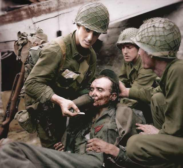 Theo thống kê từ chiến tranh thế giới thứ II, loại lưới đơn giản trùm bên ngoài mũ sắt này đã hoạt động vô cùng hiệu quả, cải thiện rất lớn về chỉ số an toàn của Quân đội Mỹ, giúp cứu sống gần 100.000 lính trong chiến tranh. Ảnh: Binh sĩ Mỹ chăm sóc đồng đội bị thương trong thế chiến II.