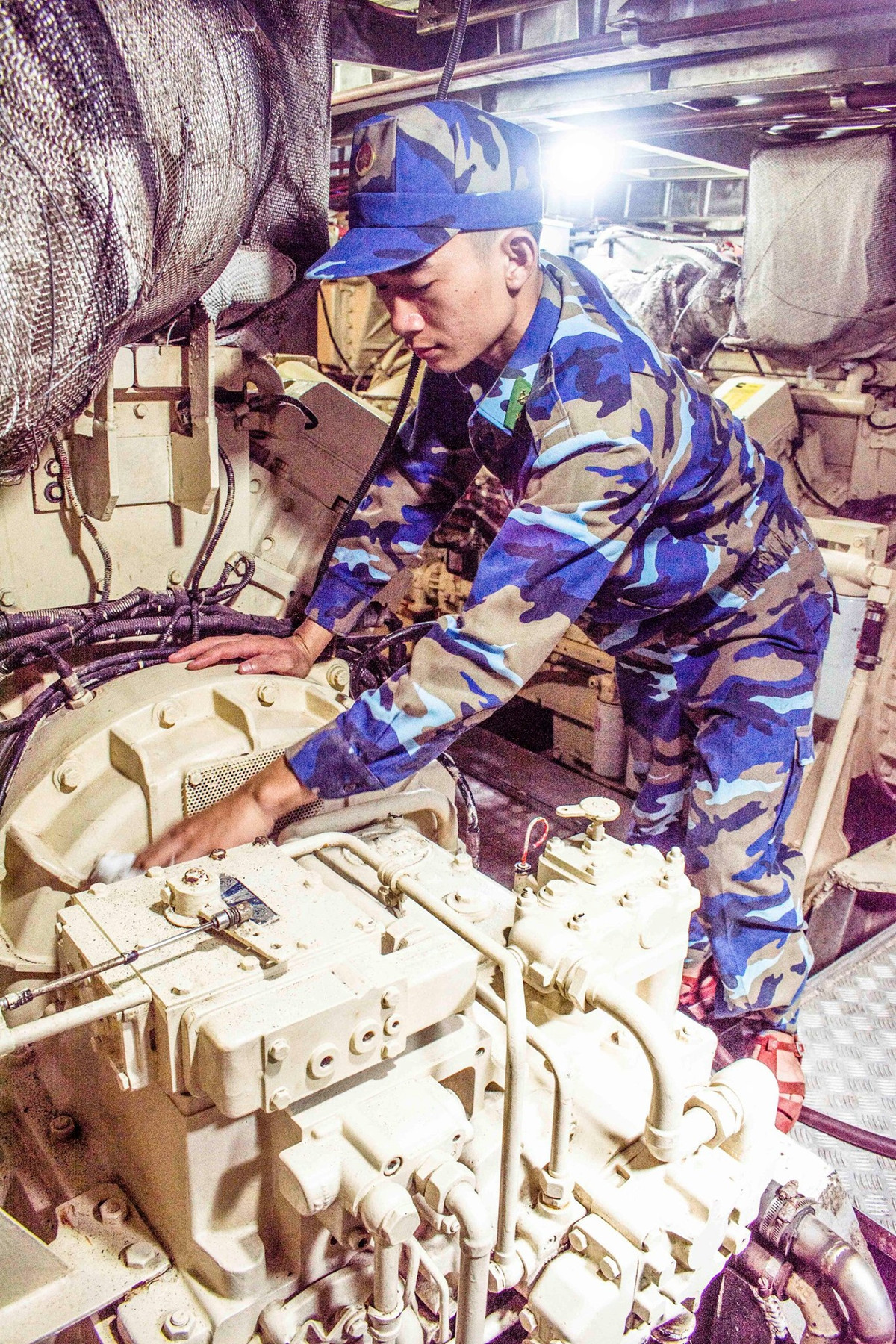 Dù tàu đã được sử dụng trong thời gian dài, điều kiện làm việc của chiến sĩ trên tàu vô cùng khó khăn tuy nhiên cán bộ chiến sĩ ngành máy vẫn luôn giữ vững vị trí, vận hành, khai thác tốt động cơ, luôn đảm bảo động cơ trong trạng thái tốt nhất và luôn sạch bóng dầu thải. Ảnh: Chiến sĩ ngành máy kiểm tra động cơ tàu Grif. Ảnh: Văn Chương.