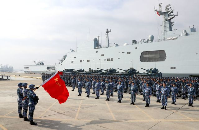 Hải quân giải phóng Trung Quốc hiện nay có đủ khả năng để triển khai đến mọi vùng biển trên địa cầu và đã hình thành được hai cụm tác chiến tàu sân bay. Cuối những năm 1990, đứng trước yêu cầu chuyển mình trở thành hải quân tầm xa, thông tin tình báo là một thứ vô cùng quan trọng trong khi hải quân Trung Quốc lại thiếu loại tàu trinh sát điện tử tầm xa có trọng tải lớn… Ảnh: Lực lượng hải quân đánh bộ Trung Quốc bên cạnh chiếc tàu đổ bộ lớp Type 071.