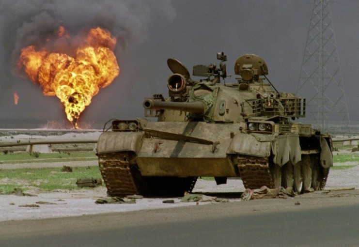 Ngày 29/11/1990, Hội đồng Bảo an Liên Hợp Quốc thông qua một nghị quyết cho phép sử dụng vũ lực quân sự chống lại Iraq nếu nước này từ chối rút quân trước ngày 15/1/1991; như vậy Saddam chấp nhận đương đầu với khoảng 700.000 quân đồng minh, chủ yếu là Mỹ, đã tập trung tại Trung Đông để buộc Iraq tuân thủ thời hạn cuối cùng. Ảnh: Xe tăng Type-69 của Iraq bị phá hủy phía sau là giếng dầu bị đốt cháy - Nguồn: AFP