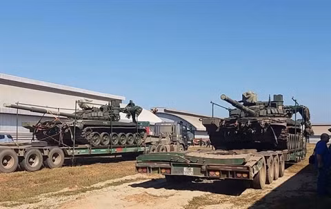 Đầu tiên chúng ta sẽ xét về bề ngoài. T-72B1MS là loại xe tăng tân trang lại từ các xe T-72B trong kho dự trữ của Nga, nó cũng sử dụng loại giáp phản ứng nổ Kontakt-1 - Thế hệ ERA đầu tiên của Liên Xô phát triển cho xe tăng. Miếng giáp có sức bảo vệ tương đương 400mm thép cán đồng nhất (RHA), tuy nhiên do sử dụng các khối nổ 4S20 có độ nhạy cảm thấp nên gần như vô dụng đối với đạn xuyên động năng. Mặc dù vậy, mức độ bao phủ bởi ERA trên T-72B1MS của Lào lại cao hơn trên T-90S/SK của Việt Nam. Ảnh: Tháo dỡ các xe tăng T-72 của Lào trên xe vận tải.