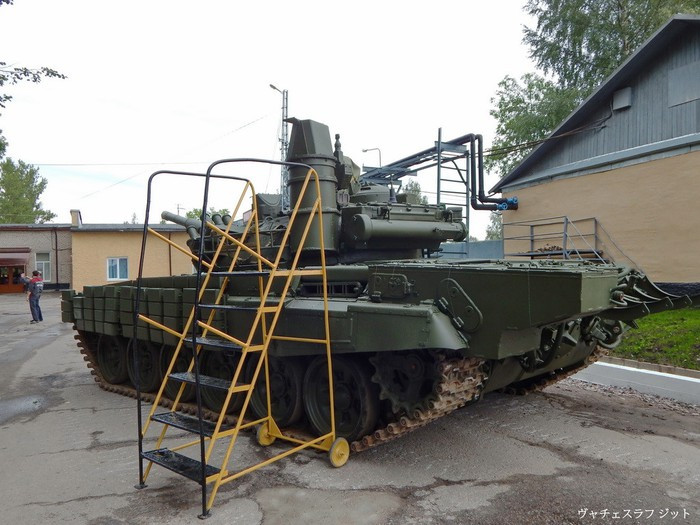 Ngoài ra, xe tăng T-72B1MS của Lào còn được trang bị một động cơ phụ trợ APU giúp xe hoạt động hệ thống điện, điều hòa,.. trong xe mà không cần khởi động máy chính, giúp xe tiết kiệm nhiên liệu cũng như tăng tính ngụy trang trên chiến trường khi xe đang nằm ẩn mình săn mồi. Động cơ điện phụ trợ (APU) này đã xuất hiện ở các xe tăng hiện đại nhất của Nga hiện nay và cả trên các xe T-90S/SK của Iraq mua từ Nga tuy nhiên xe tăng T-90S/SK của Việt Nam thì không có hệ thống này. Ảnh: Cận cảnh động cơ phụ trợ APU ở xe tăng T-72B1MS nằm ở đuôi phía bên trái của xe.