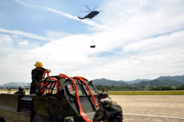 Trong lần đầu tiên xuất hiện chính thức trước công chúng, chiếc trực thăng Z-8L đã trải qua một loạt các bài kiểm tra về việc mang và nâng một xe địa hình 8×8 Bobcat, để kiểm tra tính ổn định và an toàn của quy trình vận chuyển. Ảnh: Trực thăng Z-8L thực hành nâng vật nặng – Nguồn: Snafu-solomon